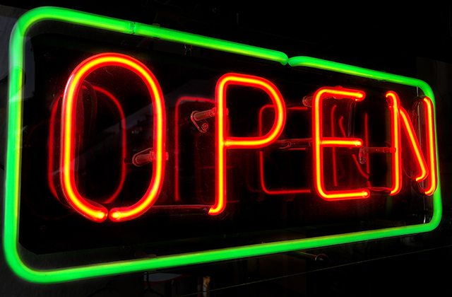 open neon sign in shop window at night